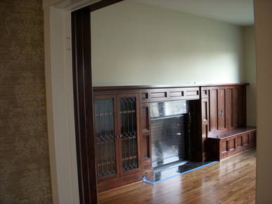 New living room mantel with built in book shelves featuring leaded glass doors.
