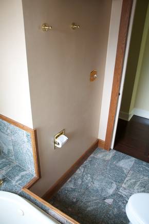 Wall adjacent to tub before it was removed to reveal extra square footage that had been walled off by a previous remodel.